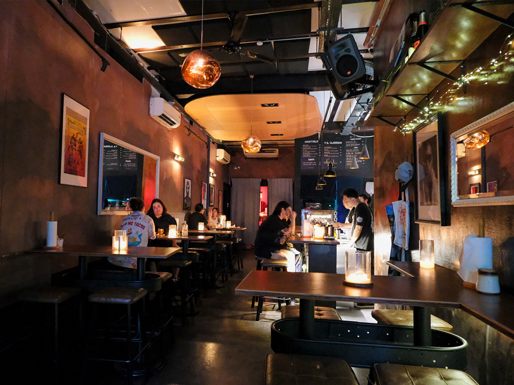 Dark wooden panels and flooring, practical but comfortable leather lounge seats, and a more than decent sound system pumping out familiar tunes. Photo: Gary Lim/HungryGoWhere Puffy Bois