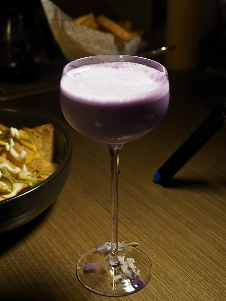 Lavender-hued cocktail dusted with coconut flakes. Photo: Angeline Ang/HungryGoWhere the lobby lounge