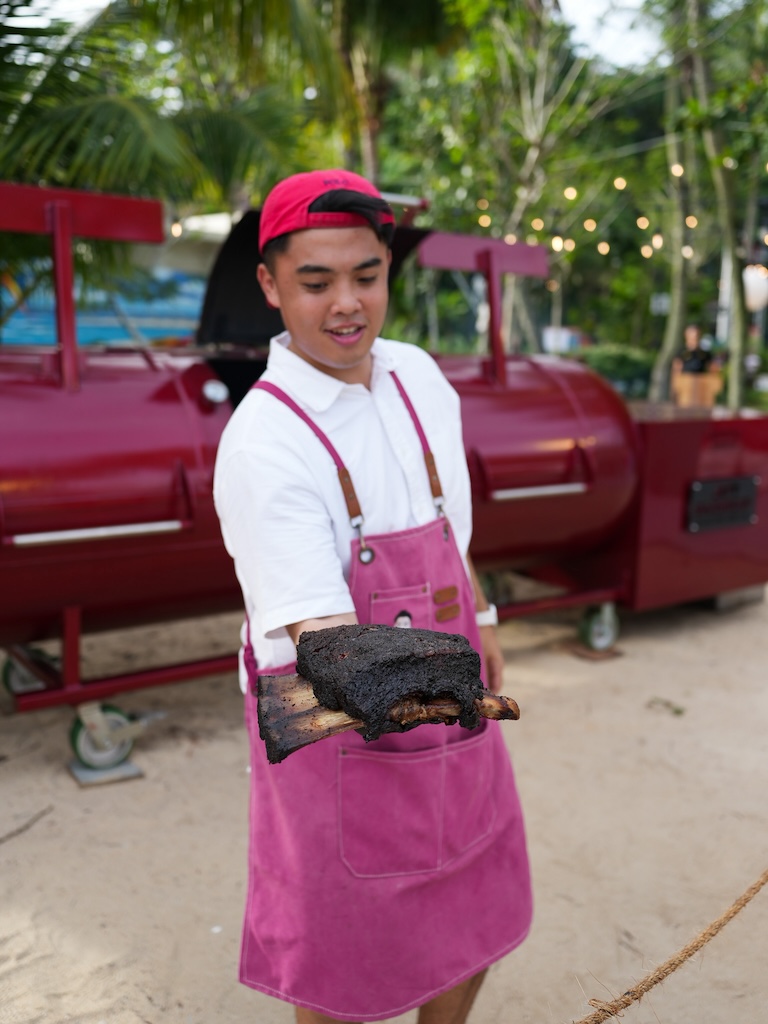 Jett shows off the ribs fresh from his iconic Texas-built smoker. Photo: Angeline Ang/HungryGoWhere sentosa grillfest 2025