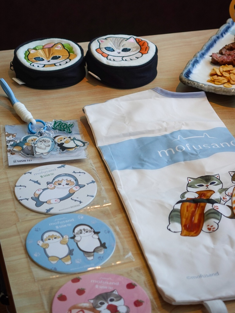 Some of the merch, including the embroidered Mofusand pouch with an eco-foldable bag, the acrylic Mofusand keychain, and the coasters which you’ll get with your drinks. Photo: Sarah Chua/HungryGoWhere Sushi Tei Mofusand collab
