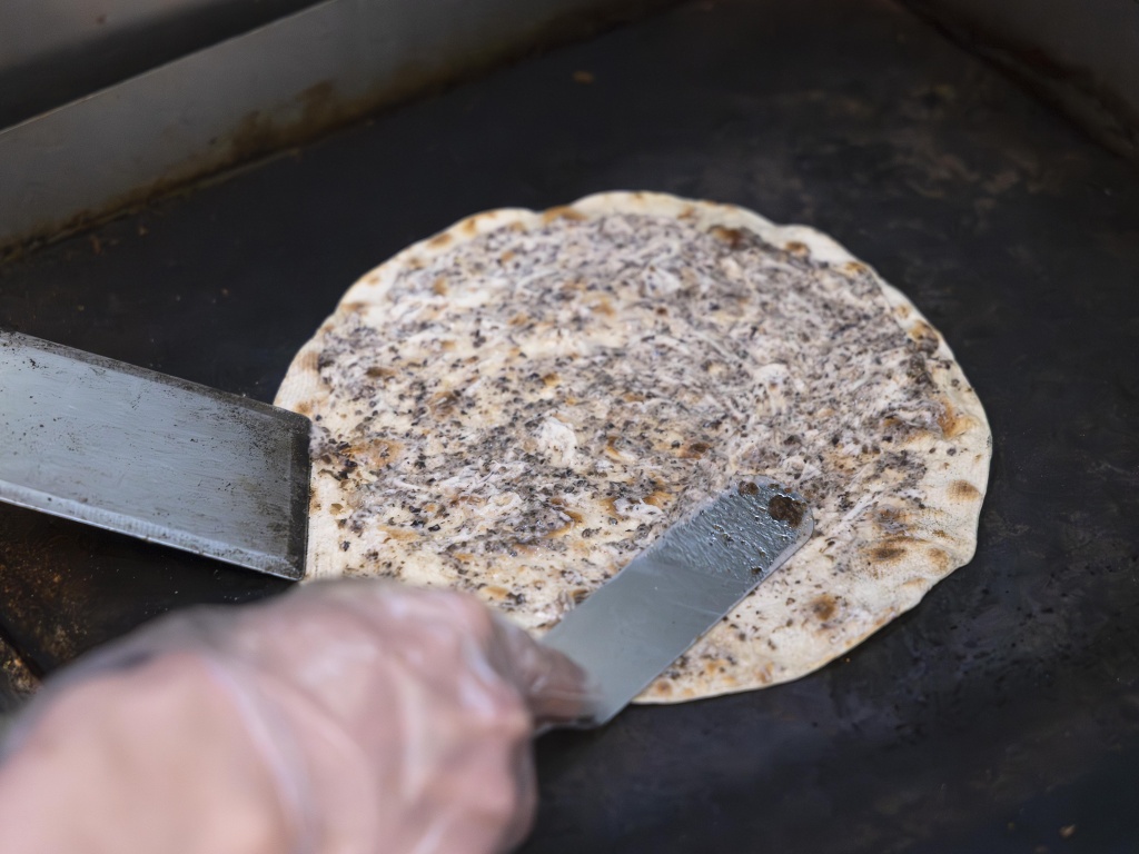 Angel adds a black truffle sauce to the piadina as it sits on the grill. Photo: Koh Mui Fong/HungryGoWhere piadini italian streats somerset piadina singapore