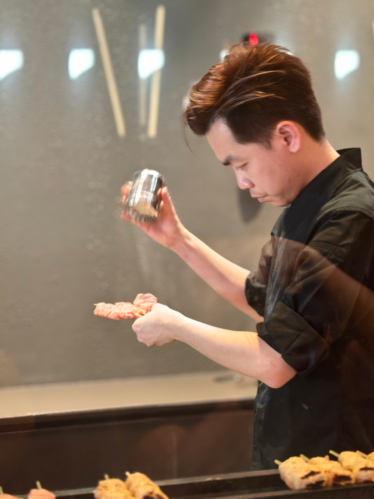 Chef Wilson seasoning a skewer before grilling it. Photo: Zawani Abdul Ghani/HungryGoWhere satori amoy street
