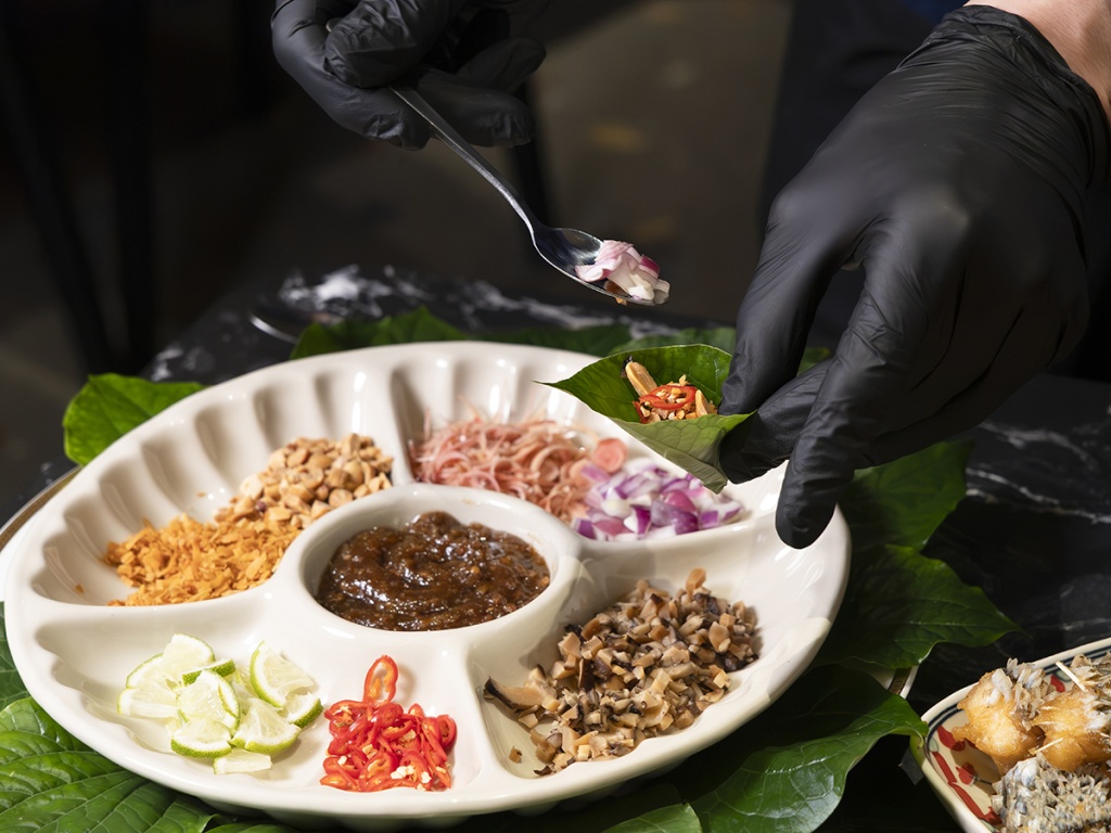 Showing us how miang kham is to be eaten. Photo: Koh Mui Fong/HungryGoWhere im qalb
